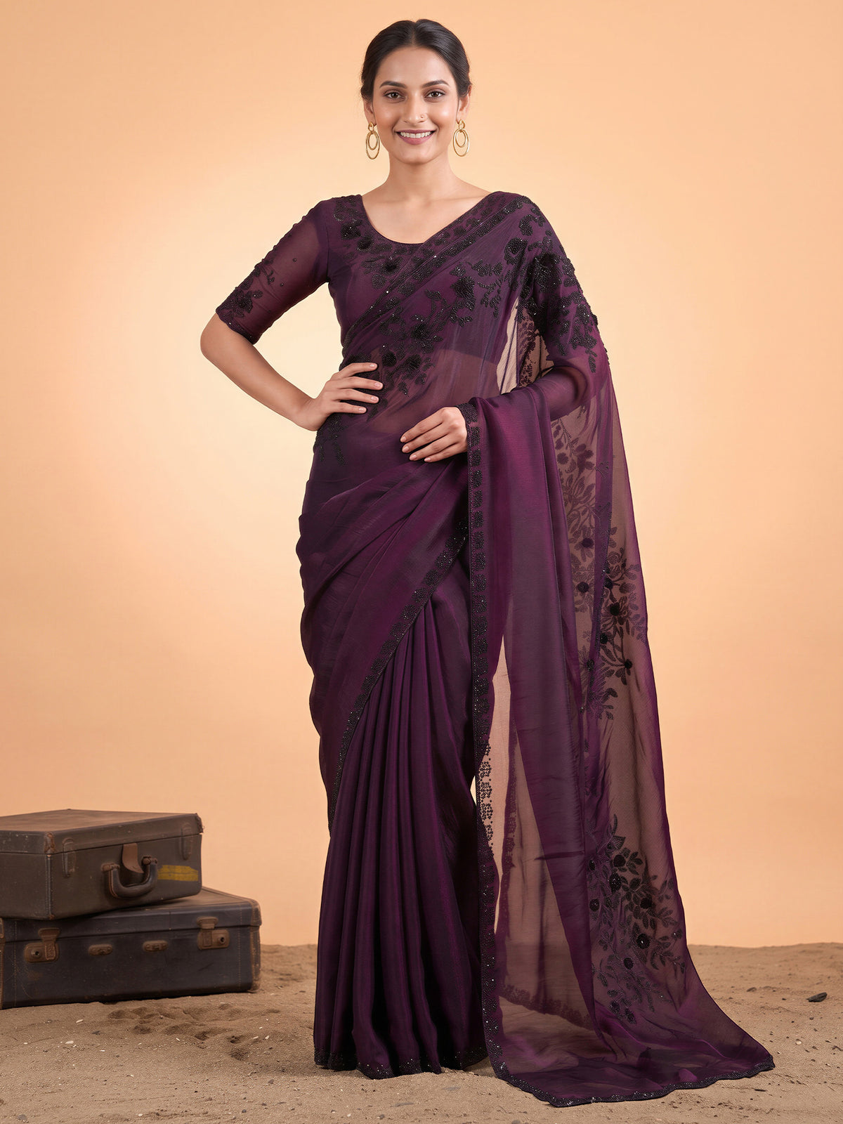 Woman wearing wine satin silk saree with ornamented surface design and wine blouse