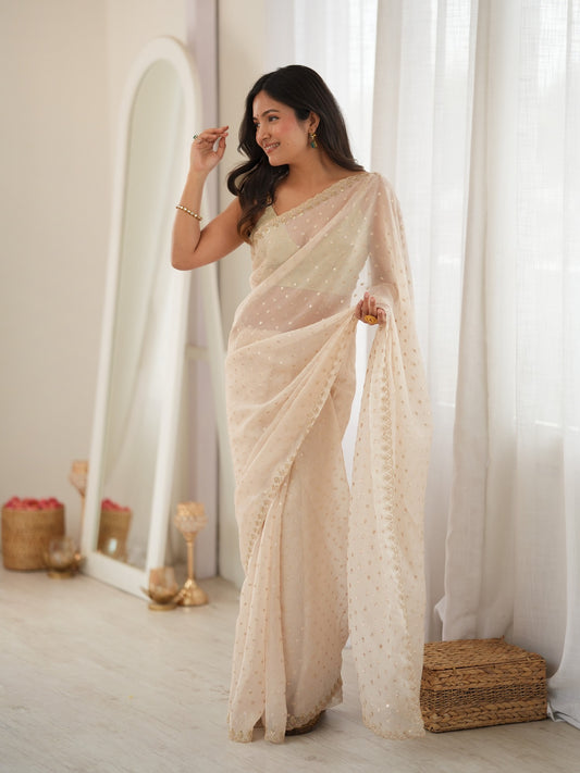 Woman wearing cream georgette saree with zari butta (metallic motif) work and cream blouse