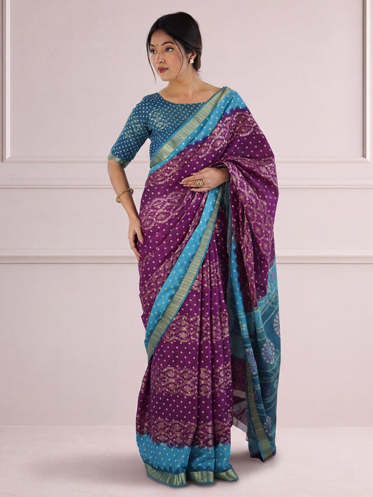 Woman wearing purple cotton saree with bandhani tie-dye dot work and light blue blouse
