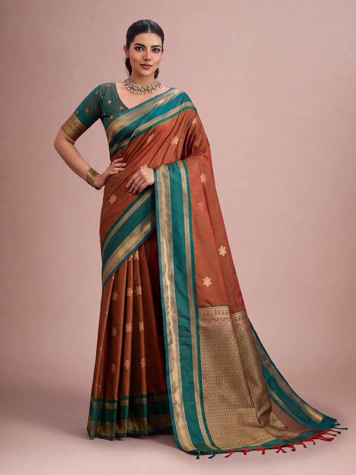 Woman wearing rust tussar silk saree with traditional indian motif work and green blouse