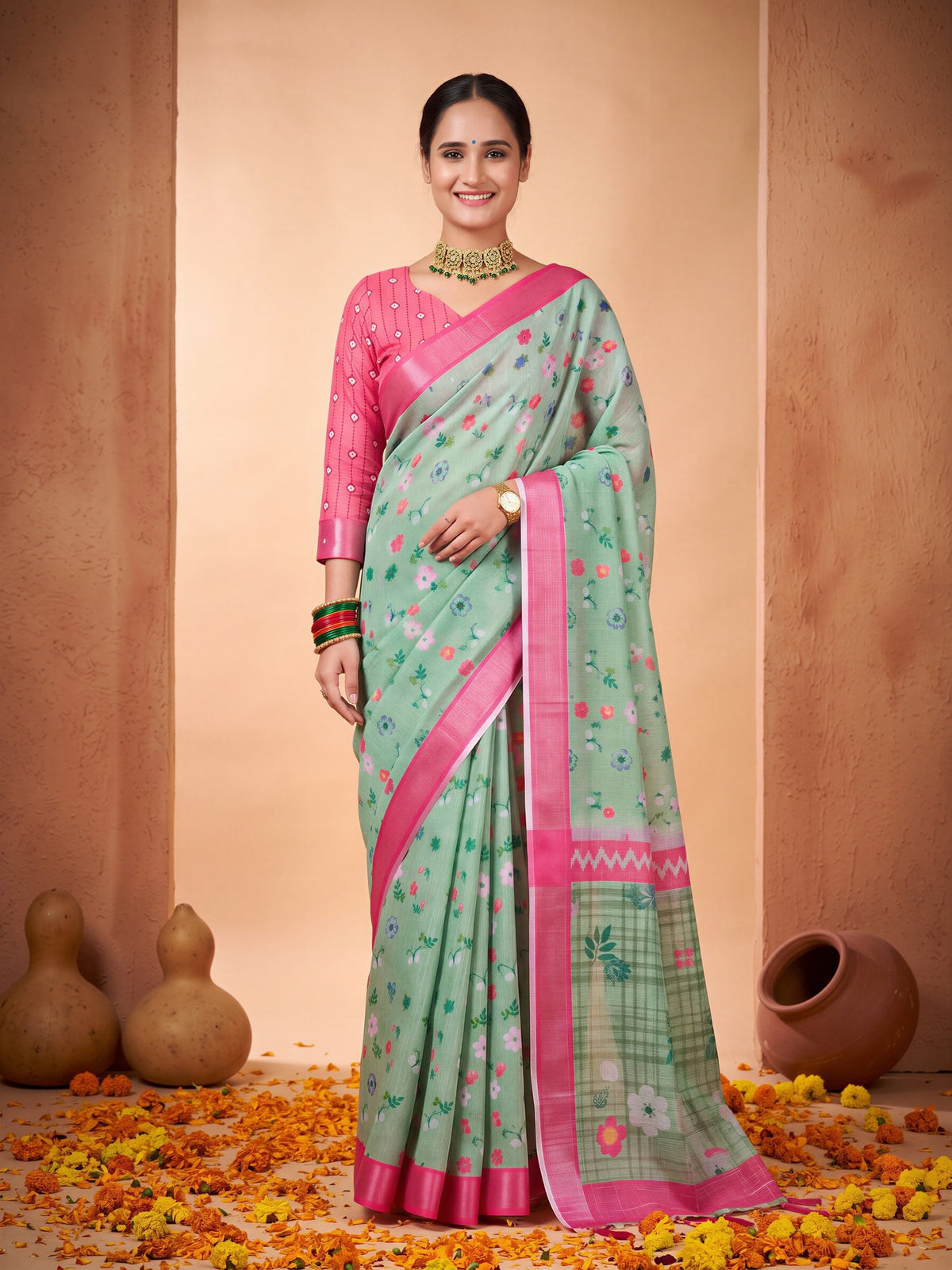 Woman wearing sea green cotton linen saree with all-over floral design and pink blouse