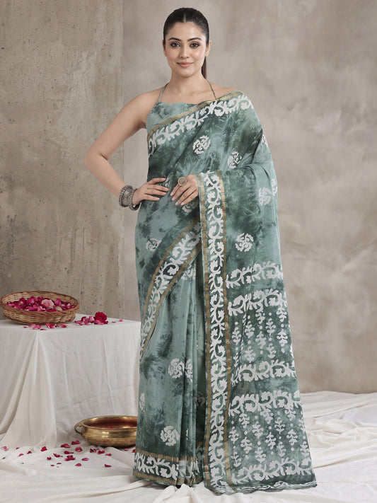 Woman wearing sea green cotton saree with shibori resist-dye pattern and sea green blouse