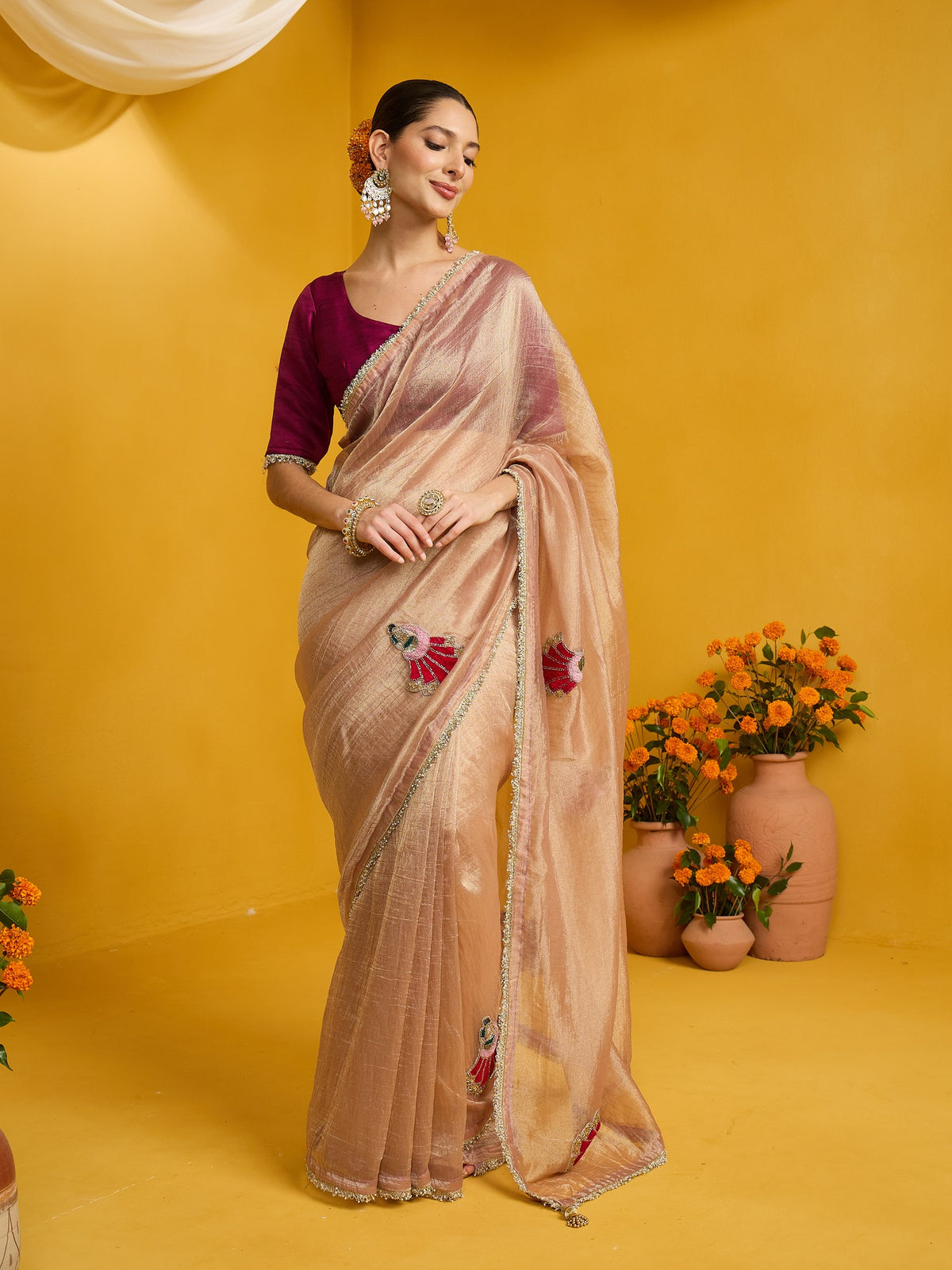 Woman wearing rose gold tissue saree with ornamented surface design and magenta blouse