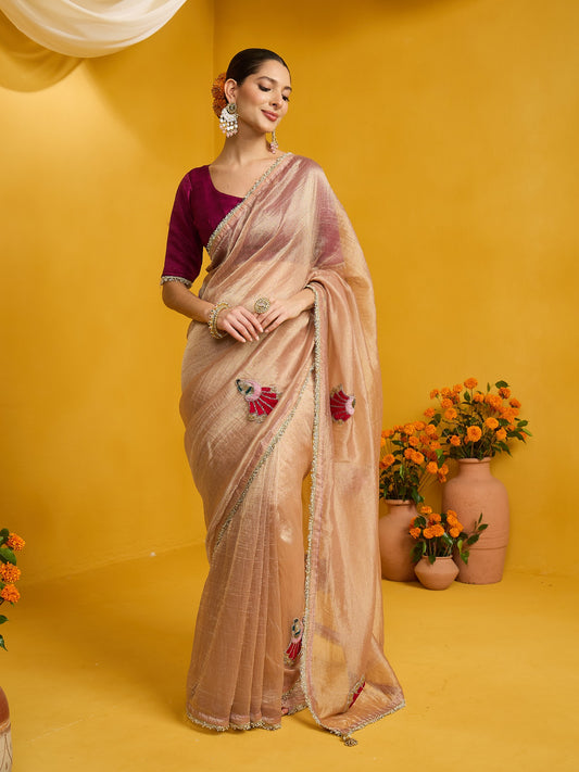 Woman wearing rose gold tissue saree with ornamented surface design and magenta blouse