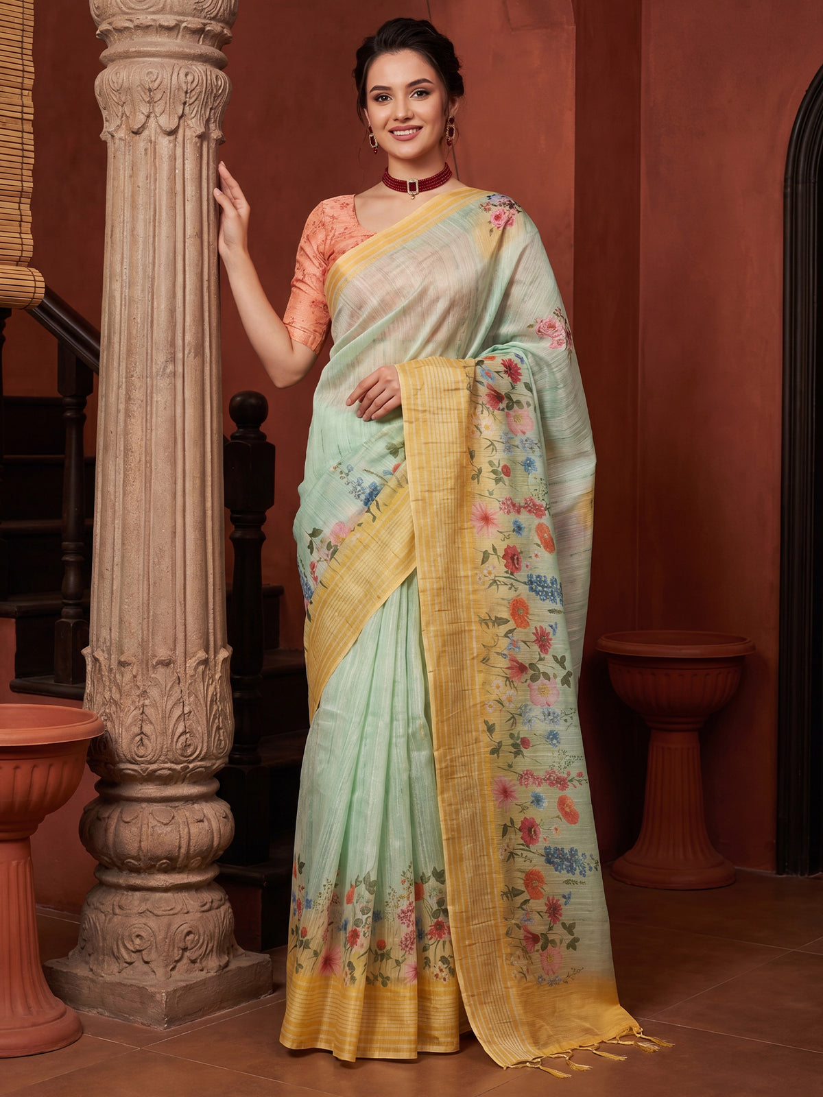 Woman wearing light blue tussar silk saree with all-over floral design and orange blouse