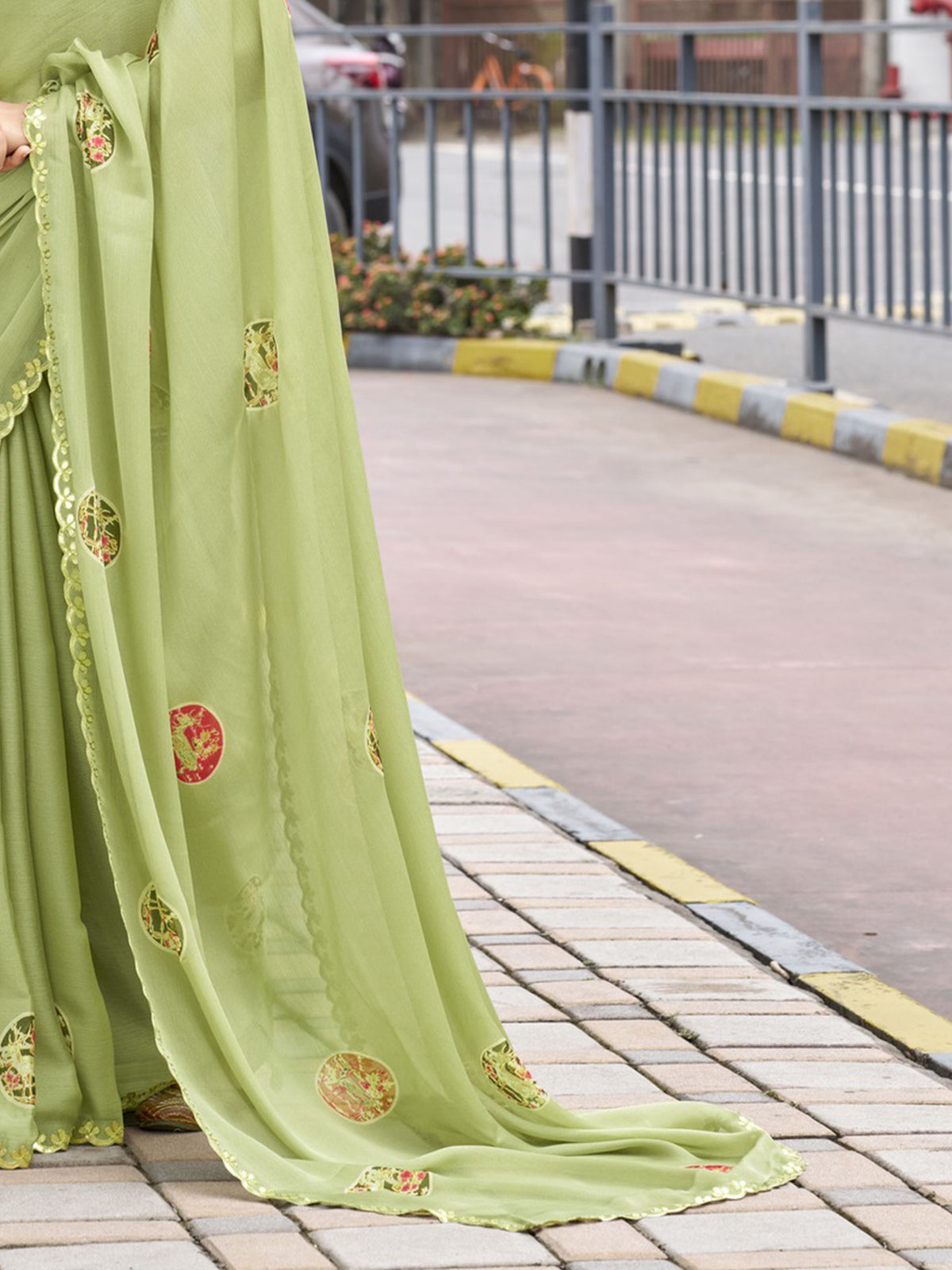 Pallu detail of sea green chiffon saree showing metallic foil print work and embellished border