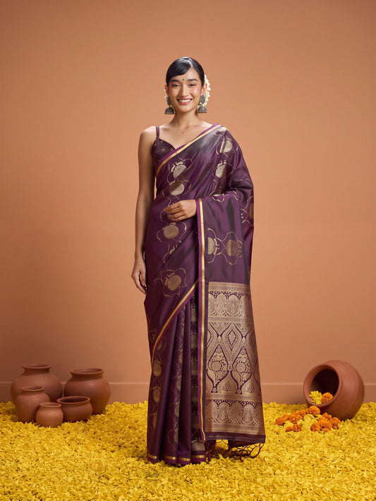 Woman wearing purple satin saree with zari butta (metallic motif) work and purple blouse