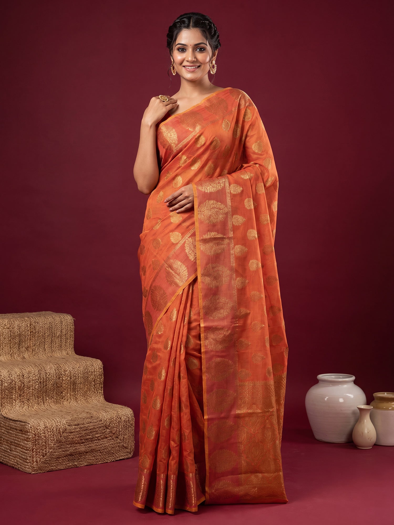 Woman wearing orange silk blend saree with zari butta (metallic motif) work and orange blouse