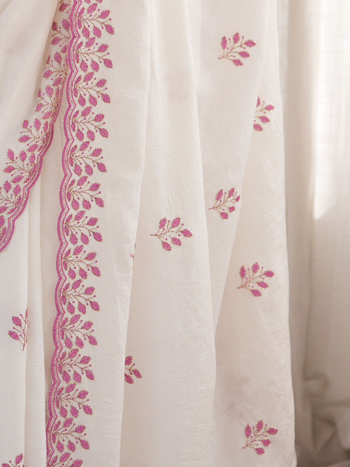 Pallu detail of white poly georgette saree showing ornamented surface design and embellished border