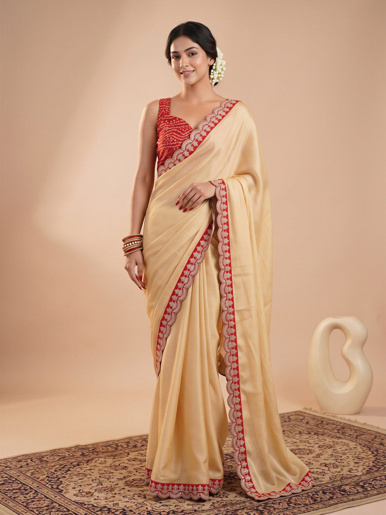 Woman wearing cream satin saree with clean solid-tone finish and red blouse