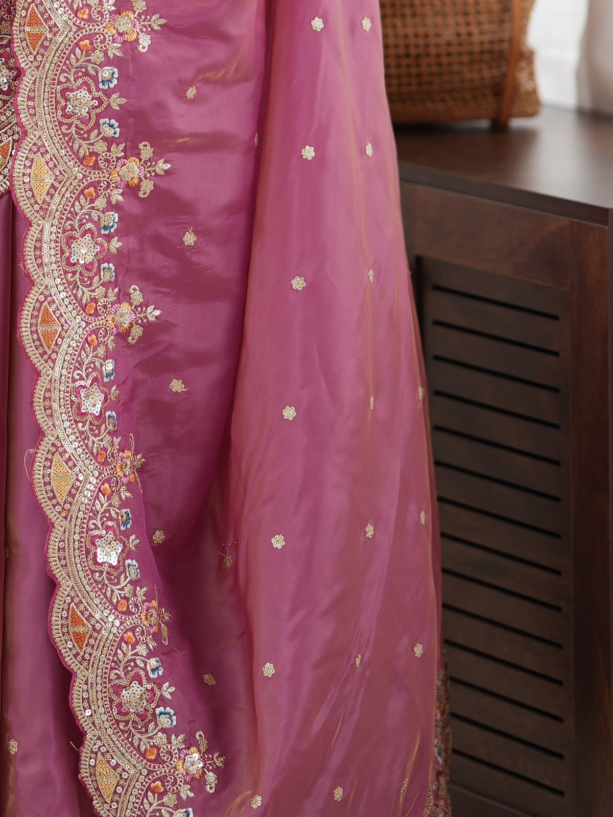 Pallu detail of mauve satin saree showing ornamented surface design and scallop border
