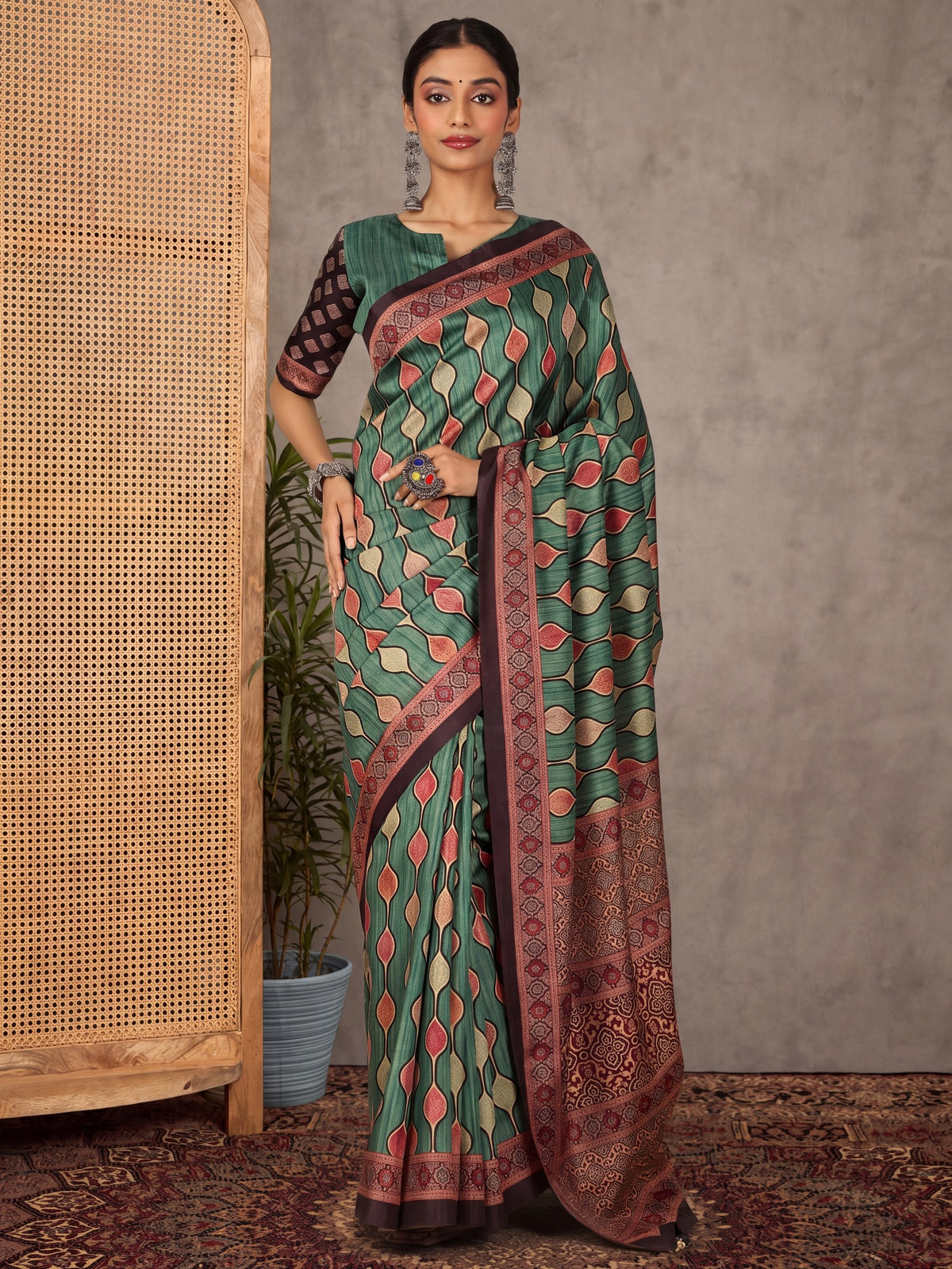 Woman wearing teal green silk blend saree with traditional indian motif work and teal green blouse