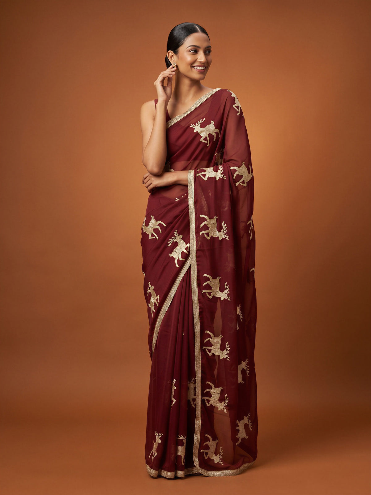 Woman wearing maroon georgette saree with embroidered motif work and maroon blouse
