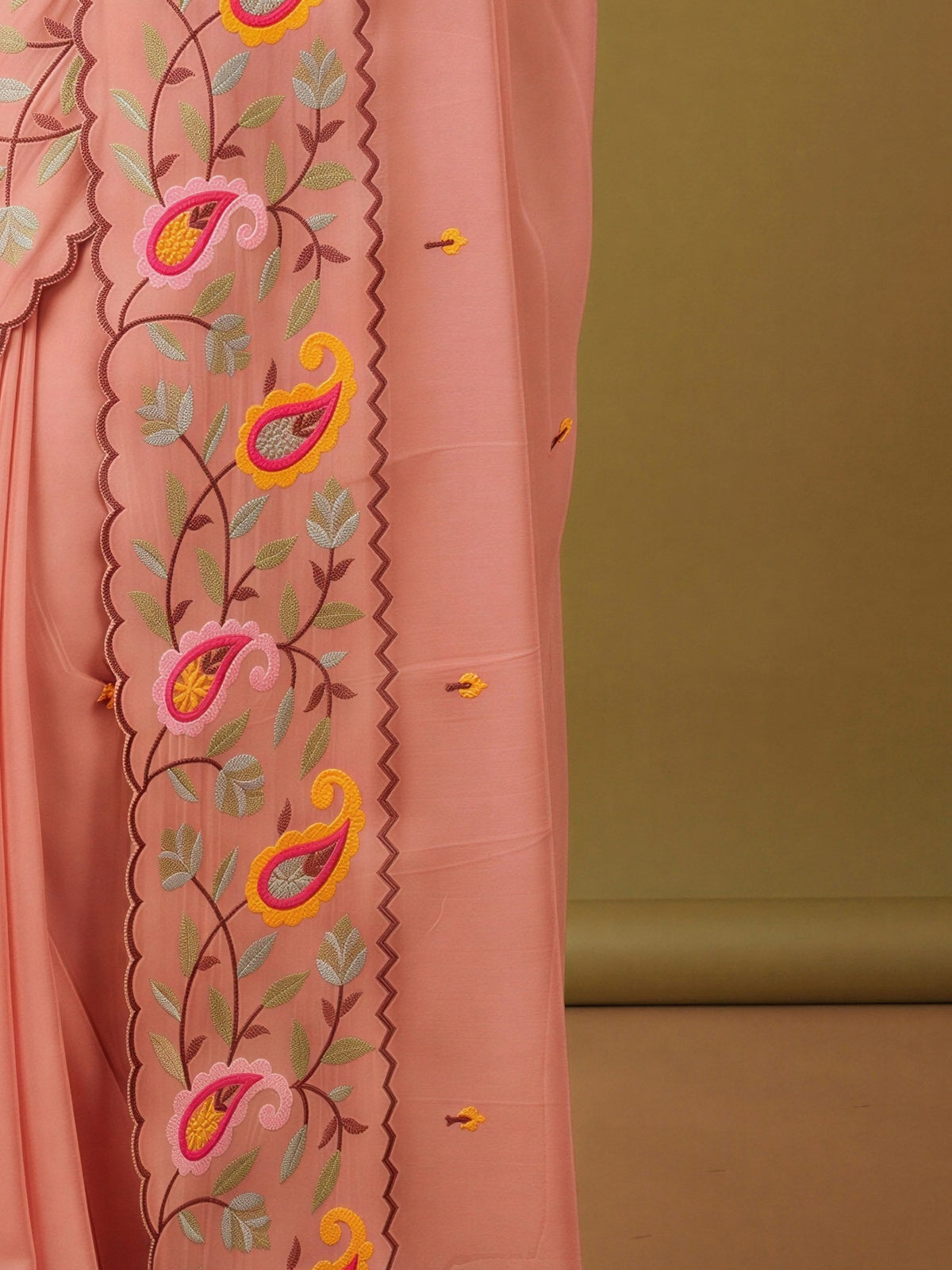 Pallu detail of peach georgette saree showing embroidered motif work and embroidered border