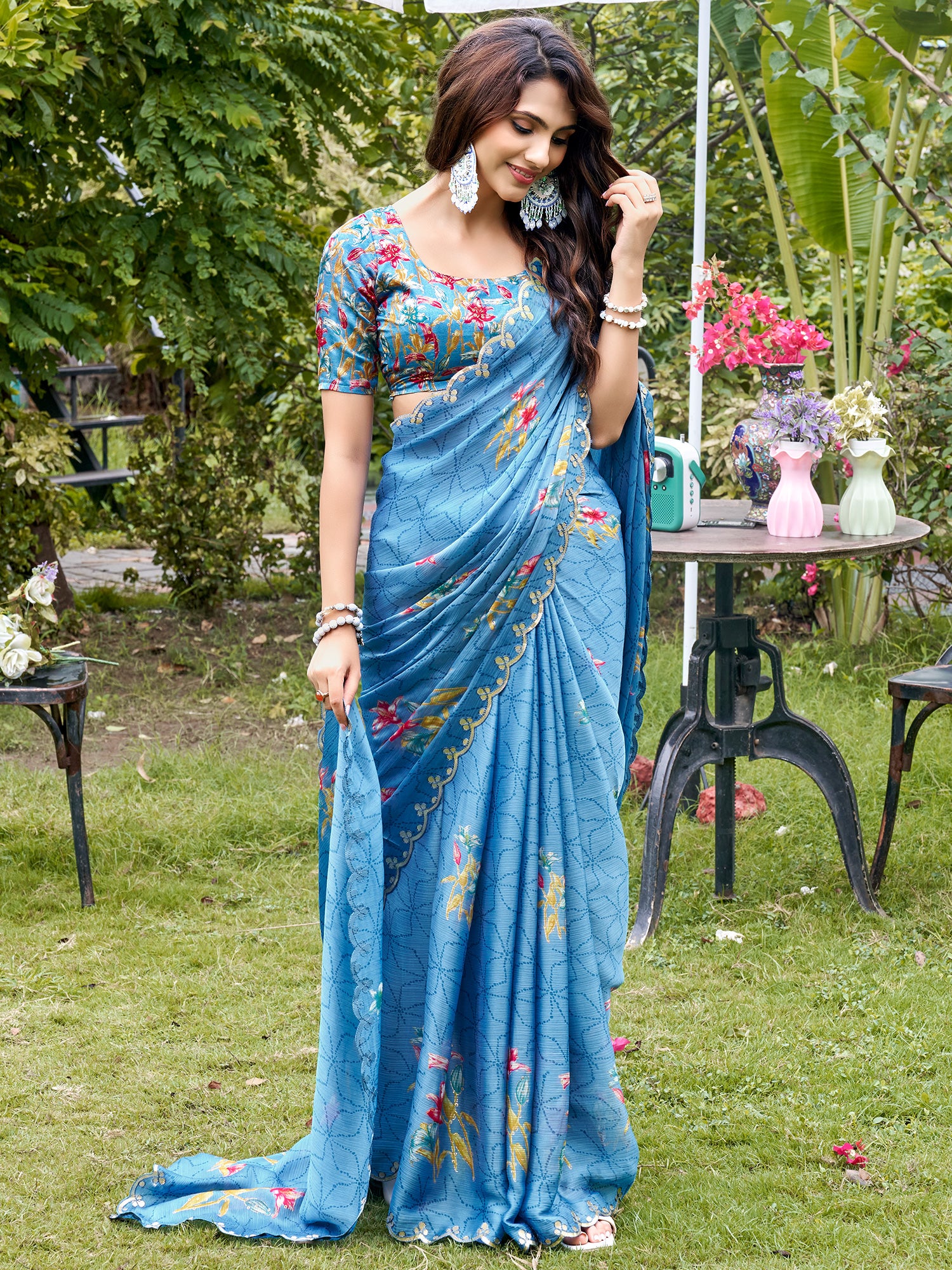 Woman wearing light blue chiffon saree with metallic foil print work and multicolored blouse