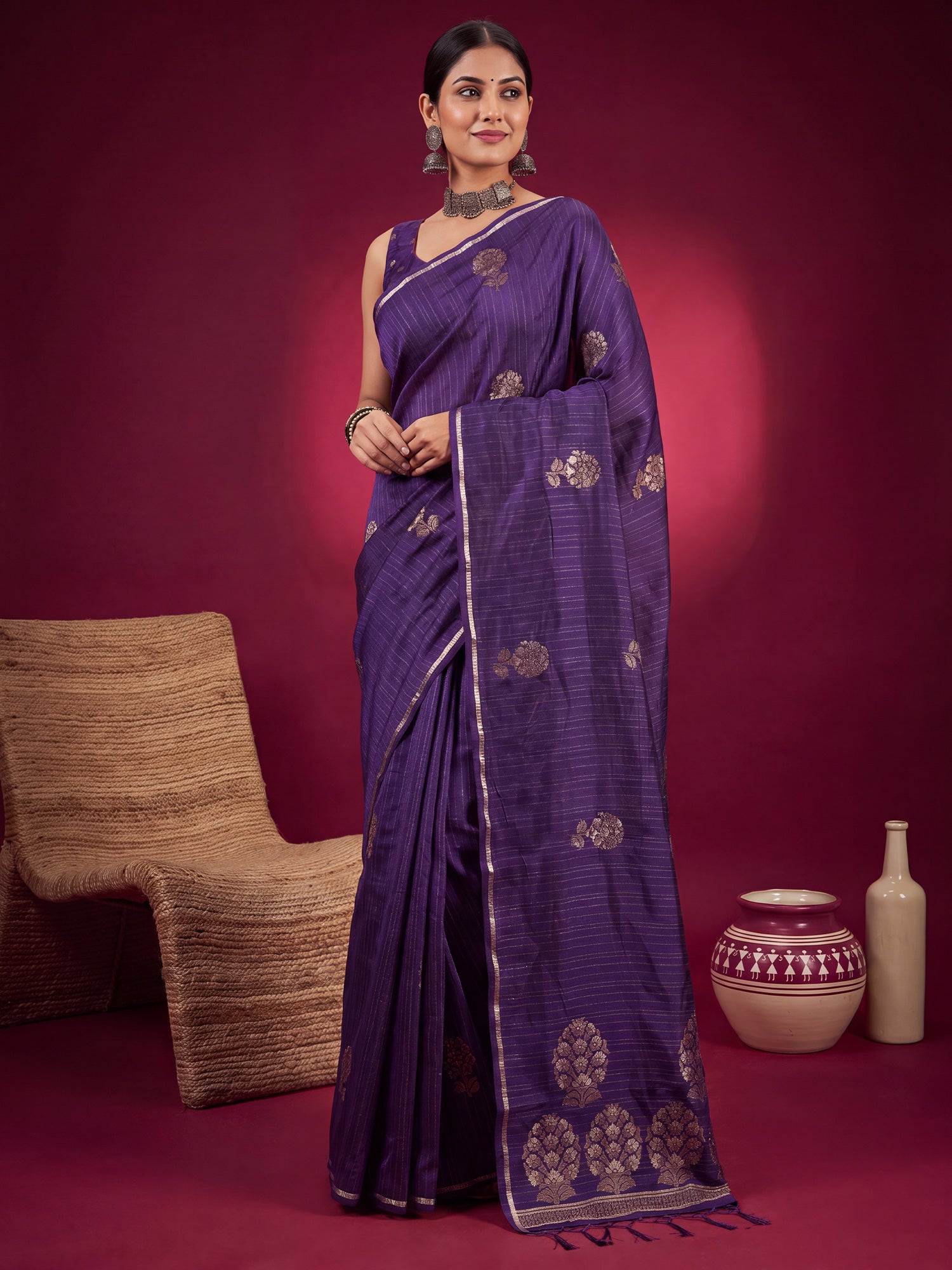 Woman wearing purple satin silk saree with zari butta (metallic motif) work and purple blouse