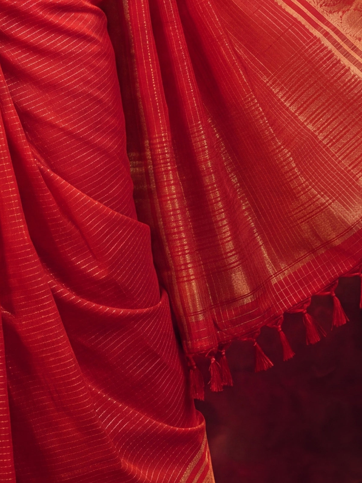 Pallu detail of red viscose saree showing traditional indian motif work and zari border