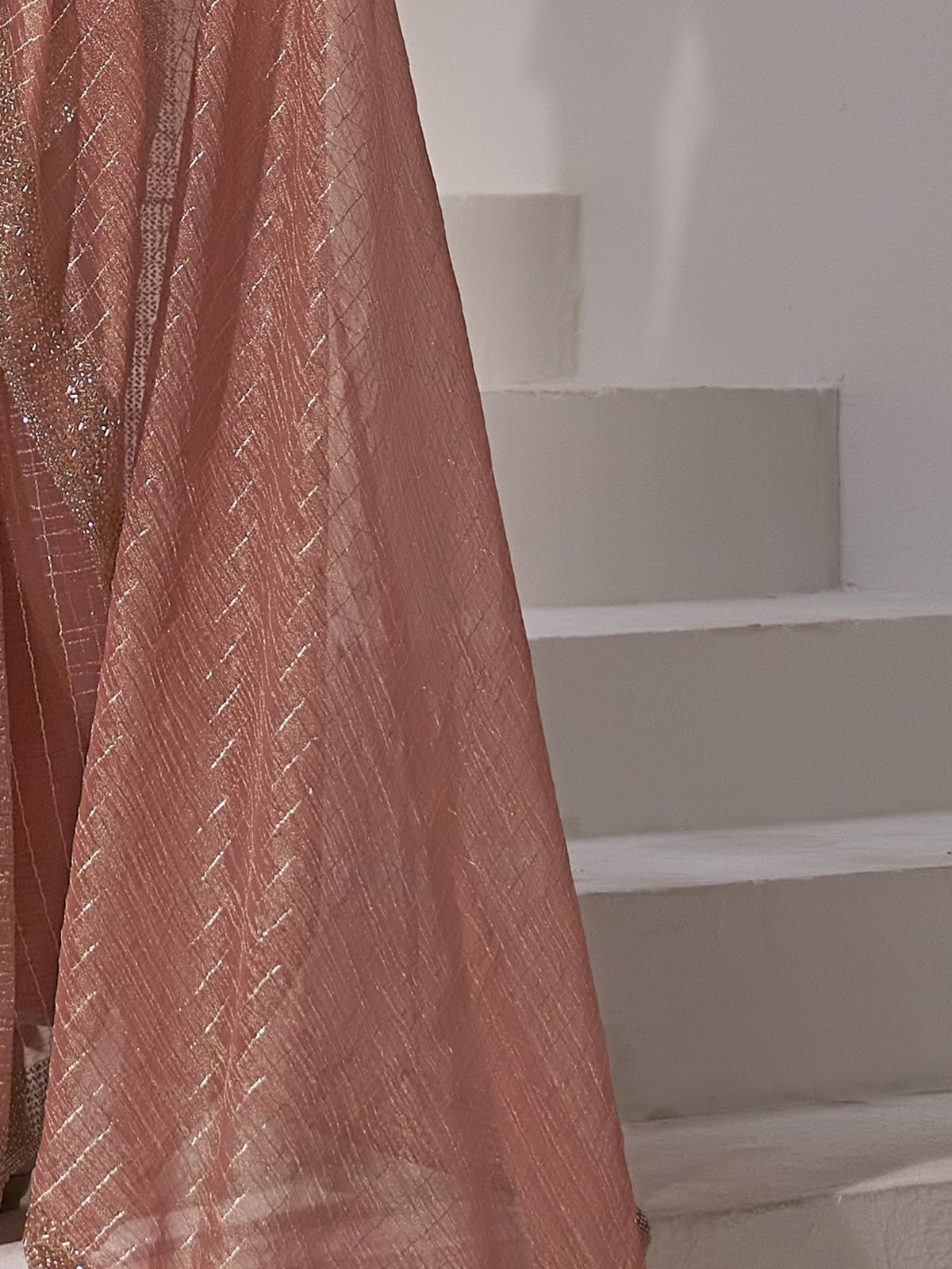Pallu detail of peach organza saree showing striped pattern design and embellished border