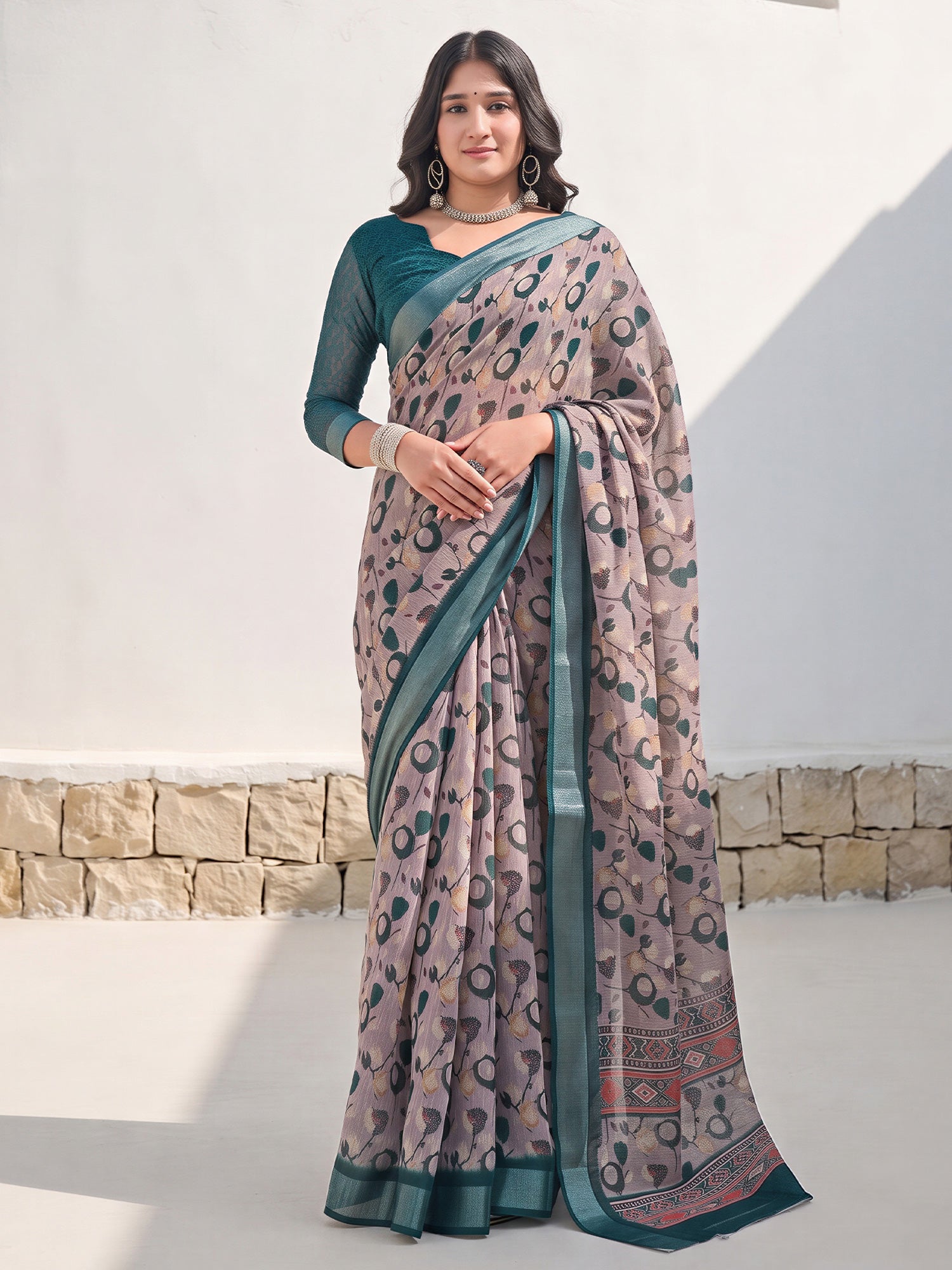 Woman wearing taupe cotton linen saree with traditional indian motif work and teal blue blouse