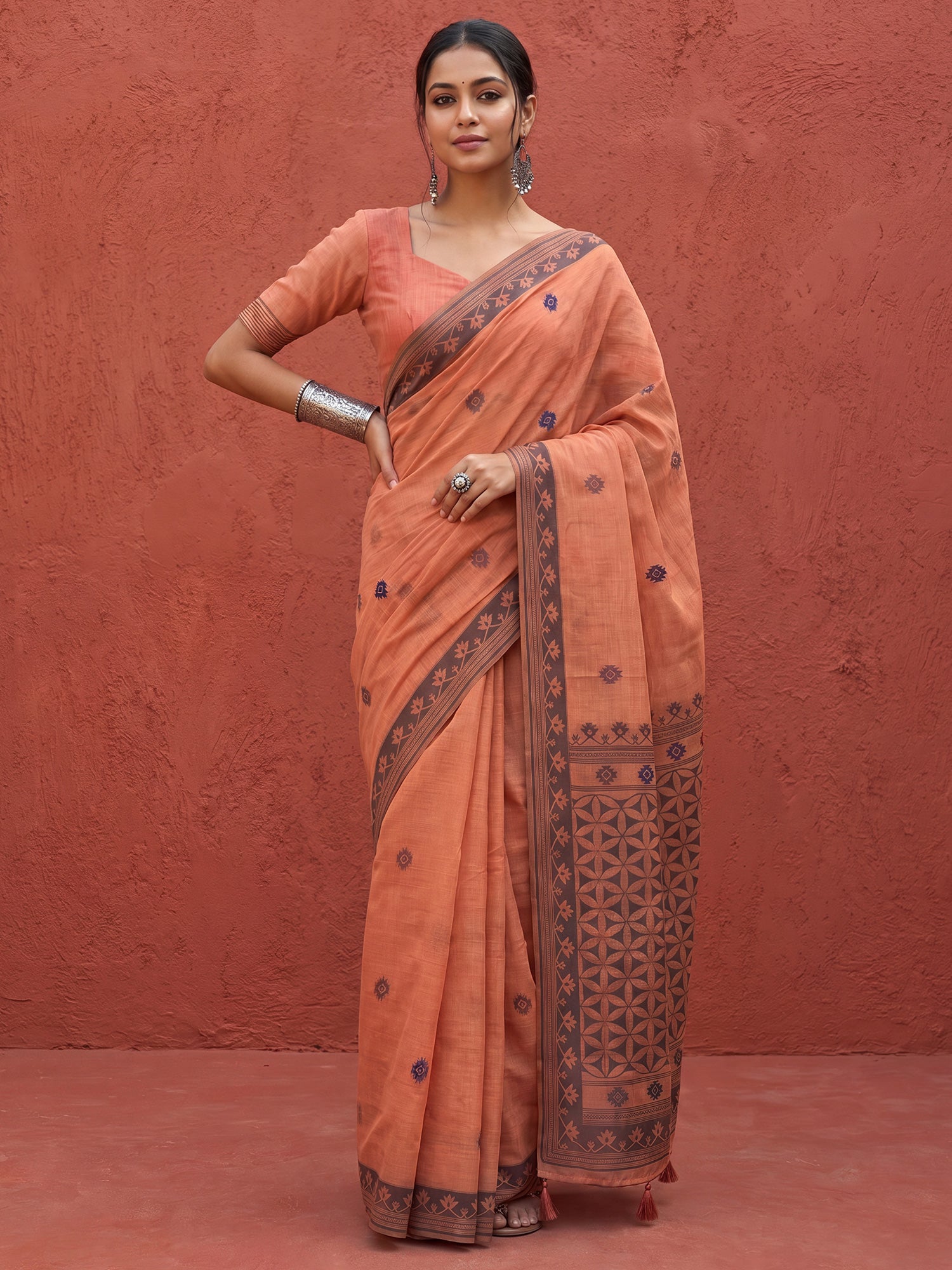 Woman wearing peach linen saree with traditional indian motif work and peach blouse