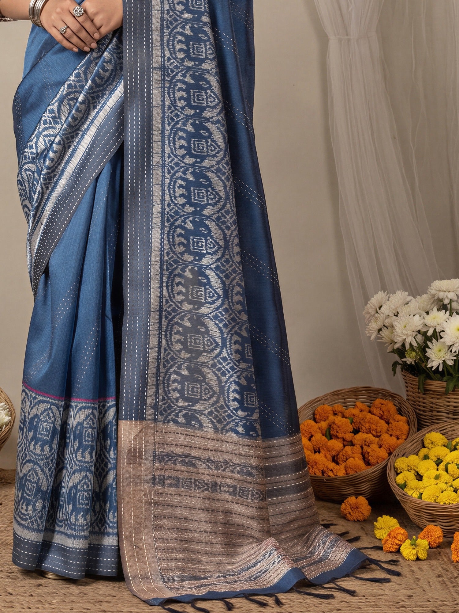 Pallu detail of blue silk cotton saree showing ikat resist-dyed pattern and embroidered border