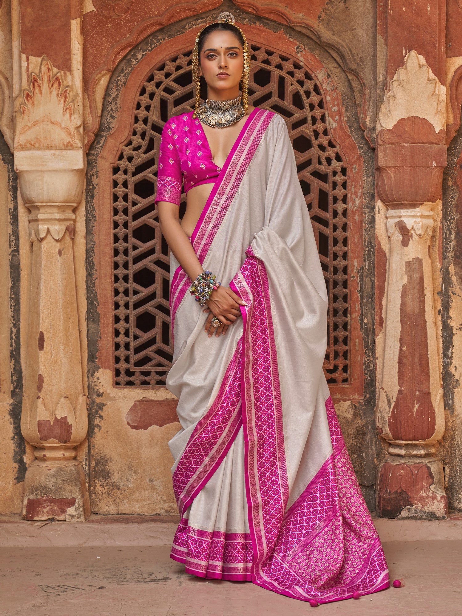 Woman wearing off white silk blend saree with clean solid-tone finish and magenta blouse