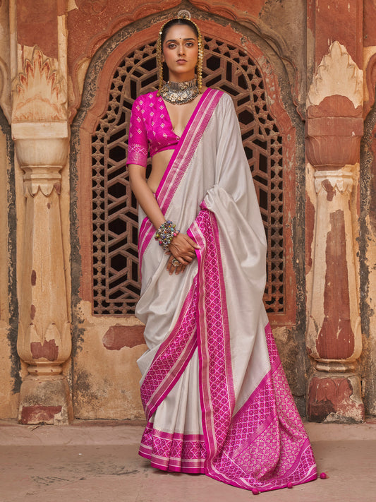Woman wearing off white silk blend saree with clean solid-tone finish and magenta blouse