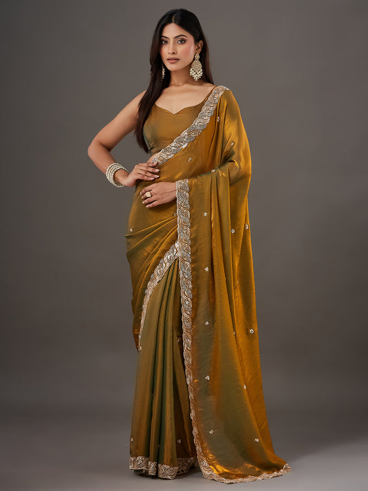 Woman wearing gold satin saree with ornamented surface design and gold blouse