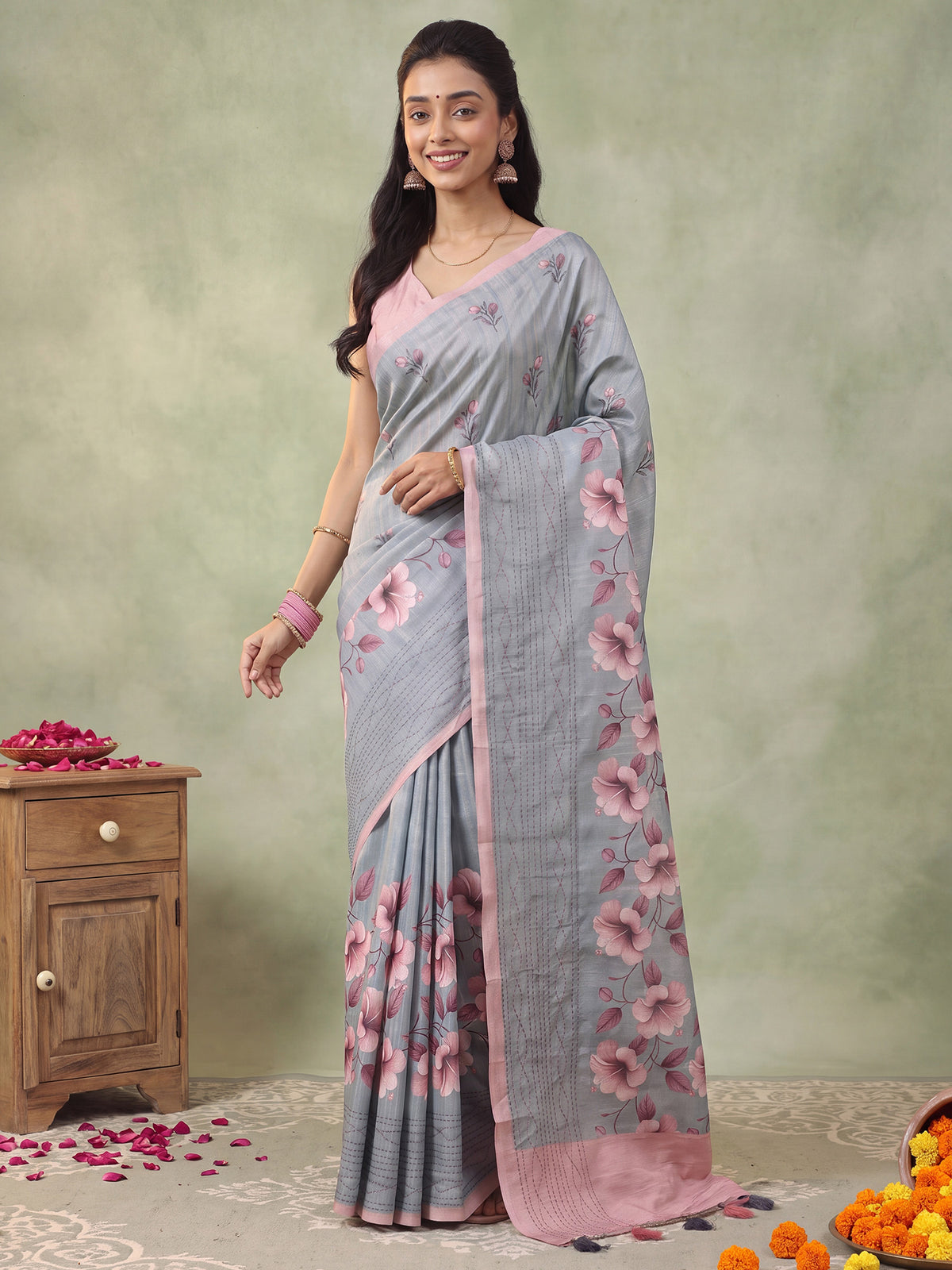 Woman wearing grey silk blend saree with all-over floral design and pink blouse