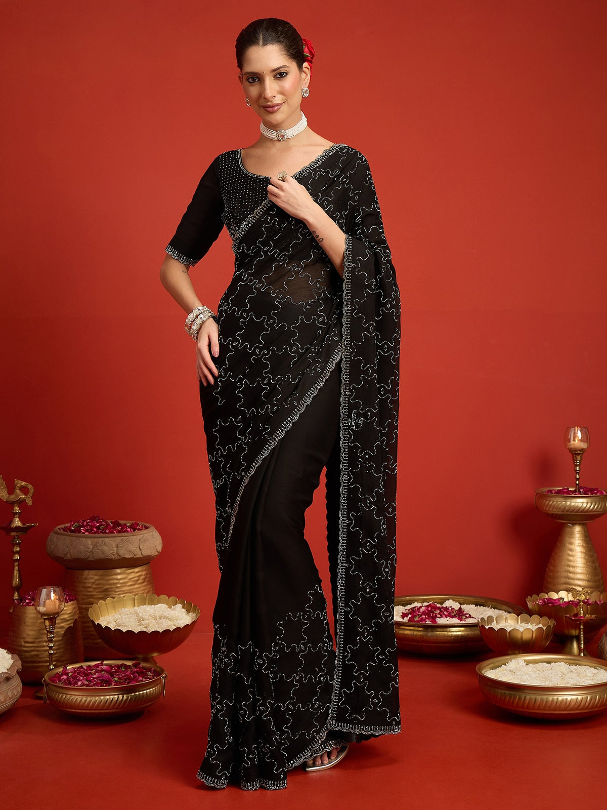 Woman wearing black chiffon saree with ornamented surface design and black blouse
