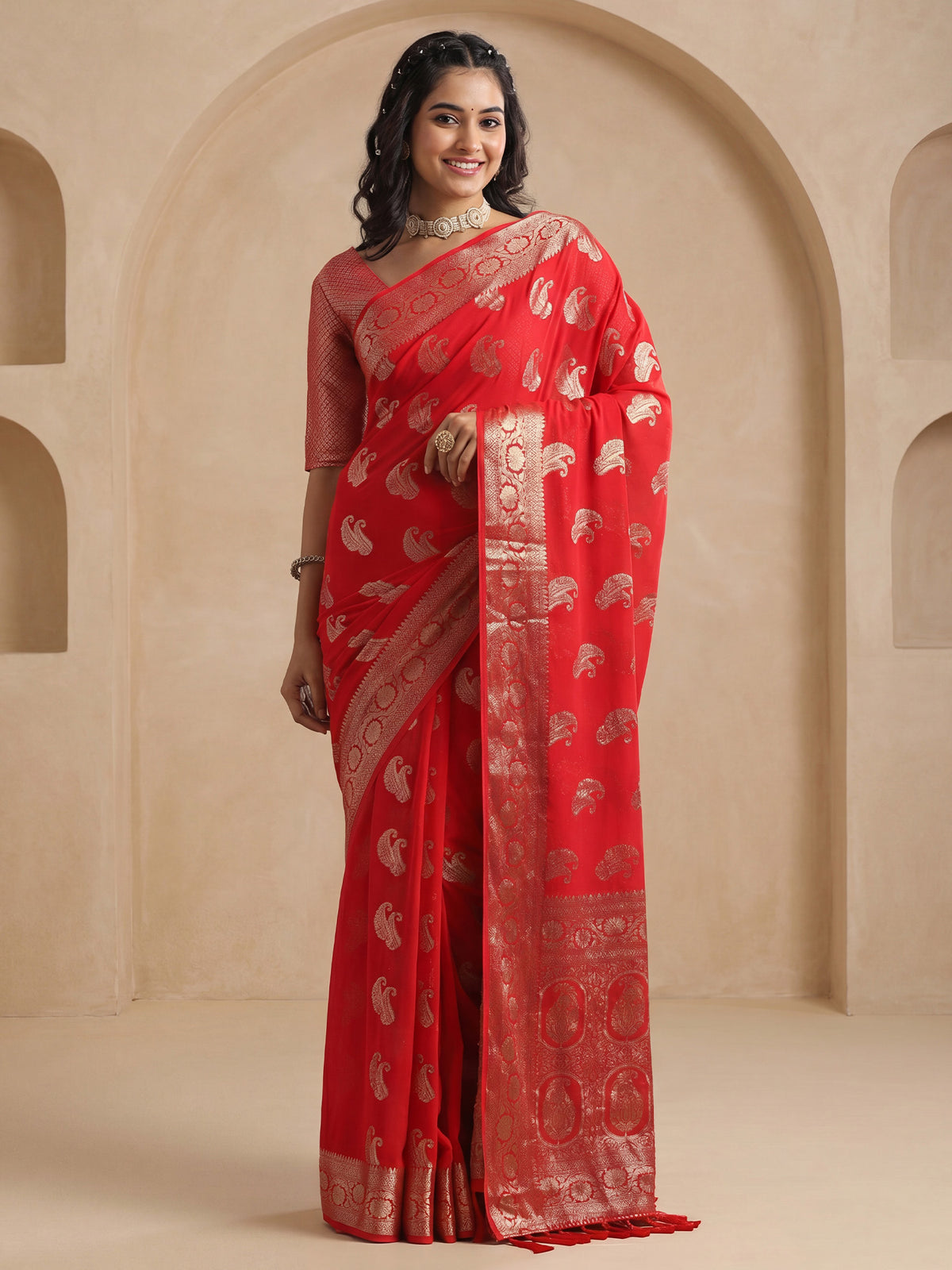 Woman wearing red georgette saree with zari butta (metallic motif) work and red blouse