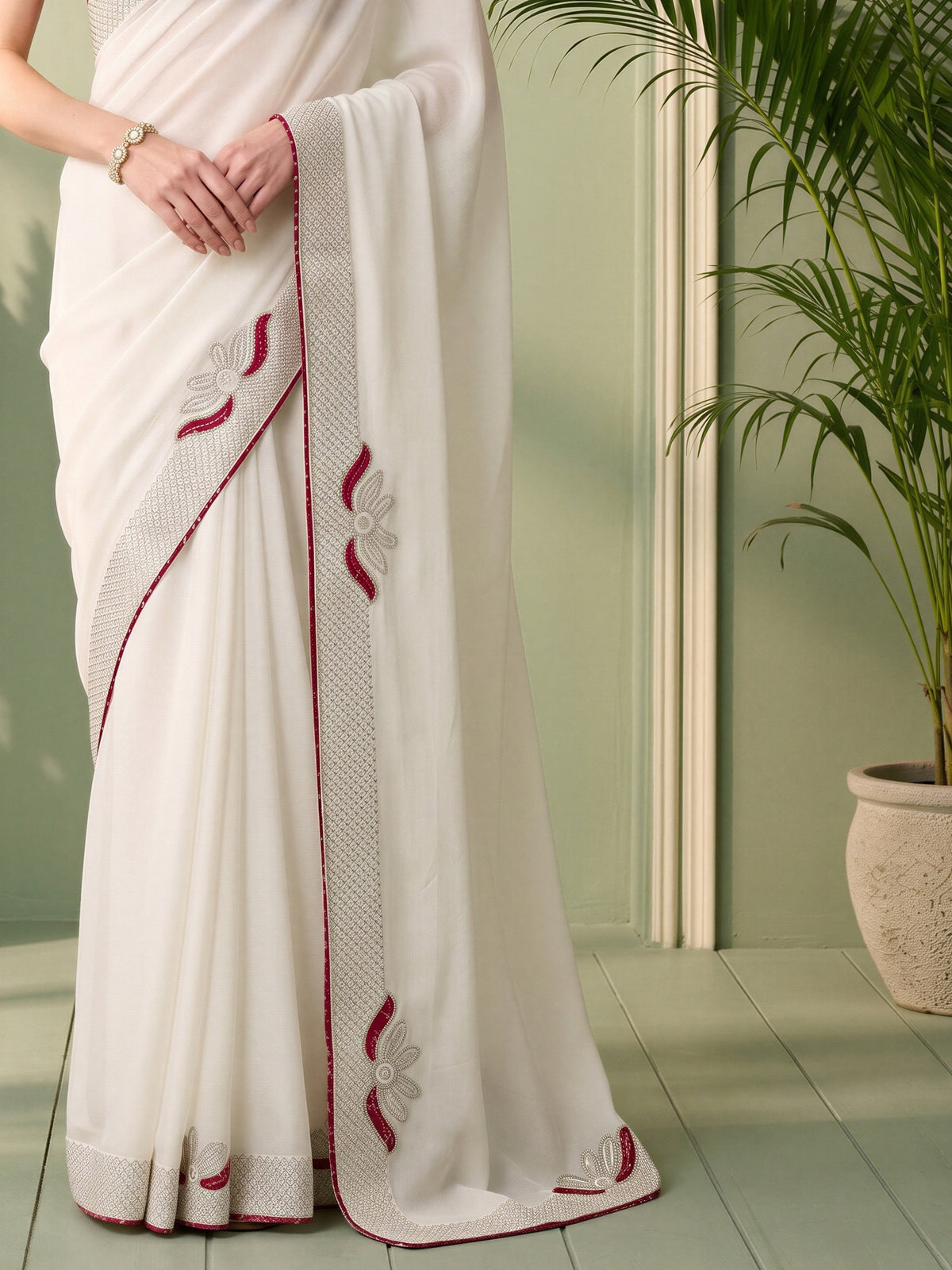 Pallu detail of white vichitra silk saree showing ornamented surface design and embellished border