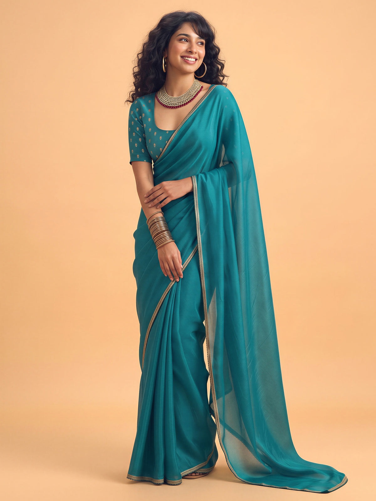 Woman wearing teal blue silk saree with clean solid-tone finish and teal blue blouse