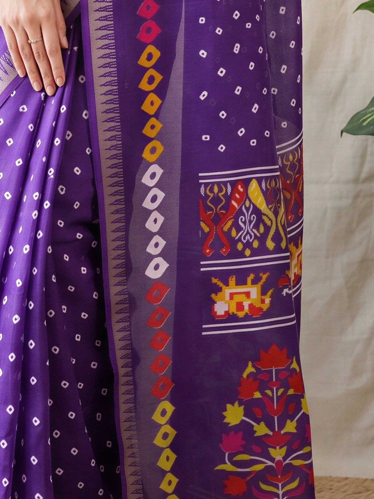 Pallu detail of purple georgette saree showing bandhani tie-dye dot work and zari border