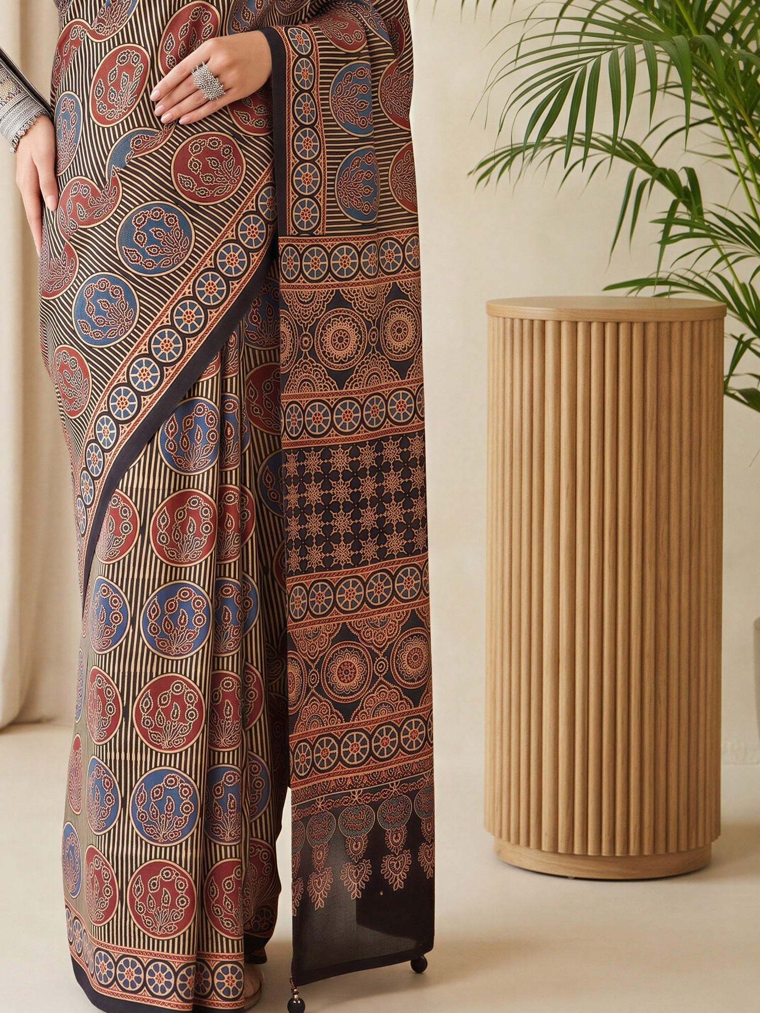 Pallu detail of black silk blend saree showing traditional indian motif work and printed border