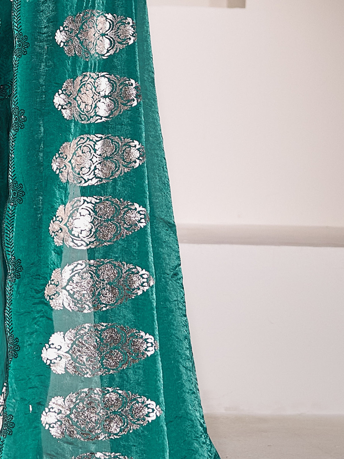 Pallu detail of teal green satin silk saree showing metallic foil print work and embellished border