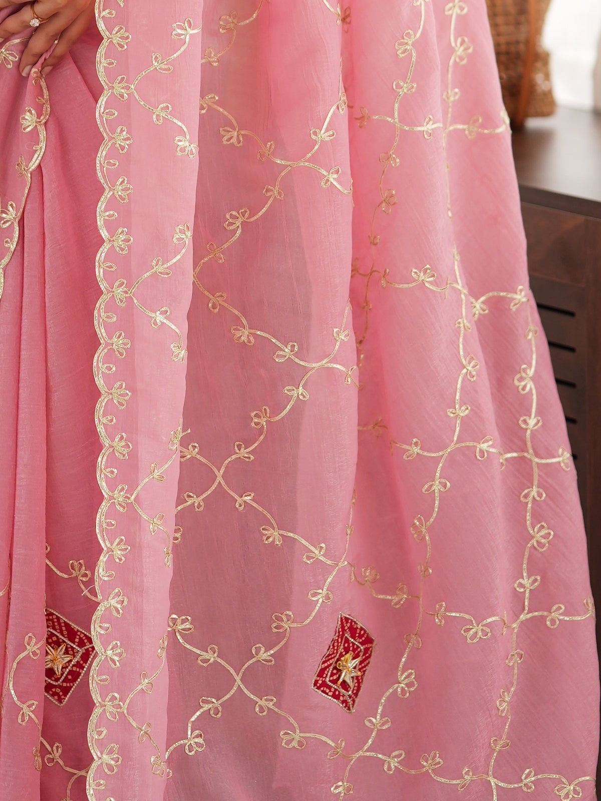 Pallu detail of pink paper silk saree showing ornamented surface design and embellished border