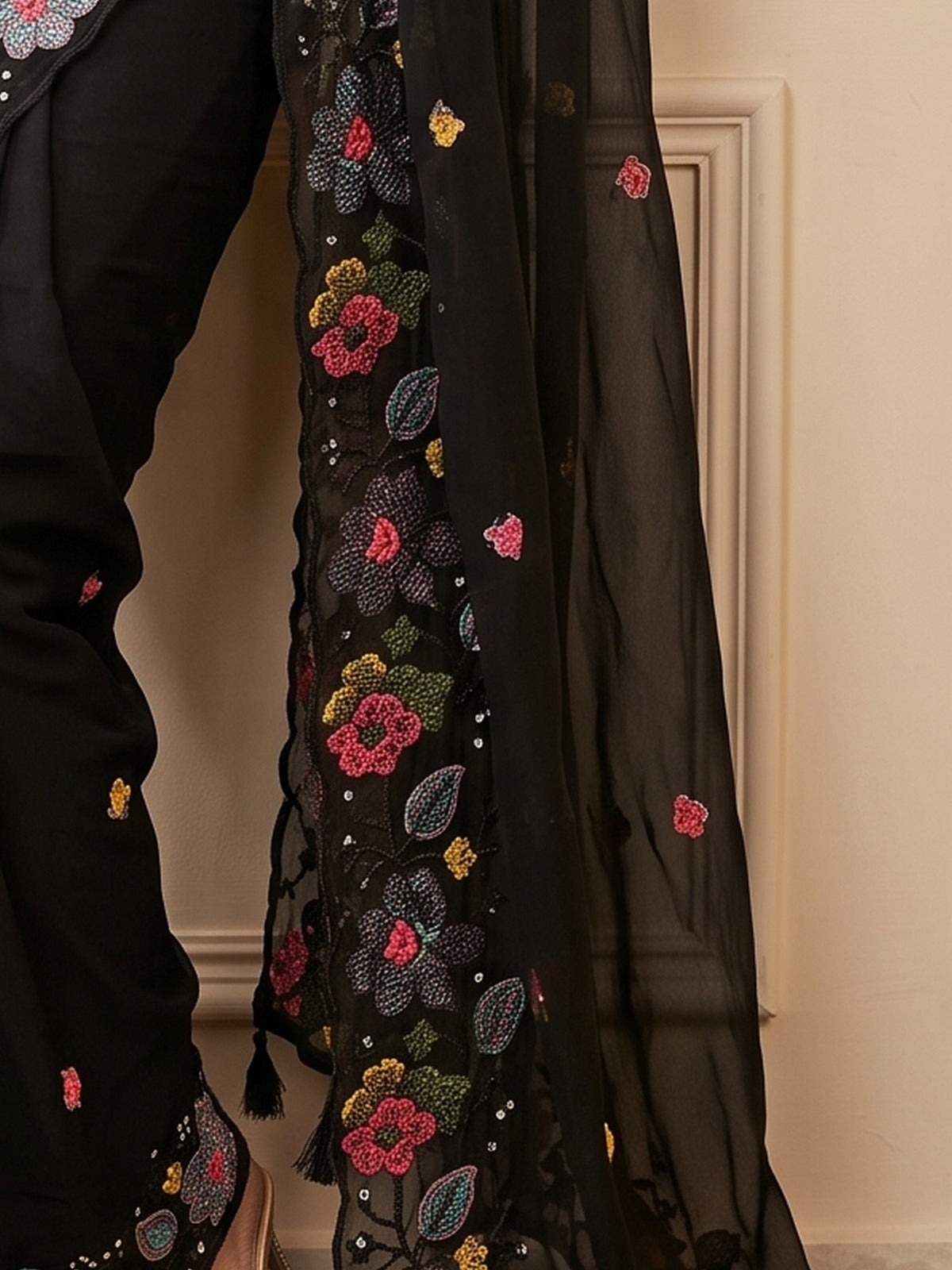 Pallu detail of black georgette saree showing embroidered motif work and embellished border