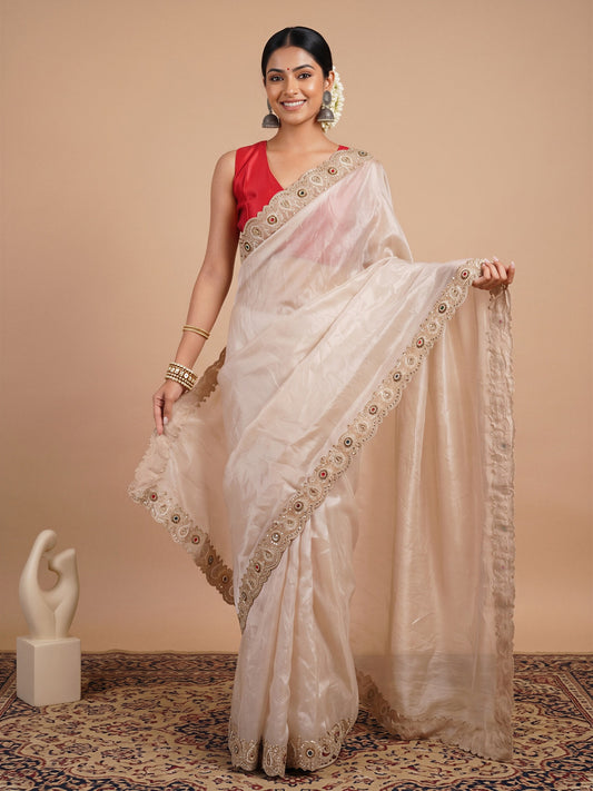 Woman wearing off white satin saree with ornamented surface design and red blouse