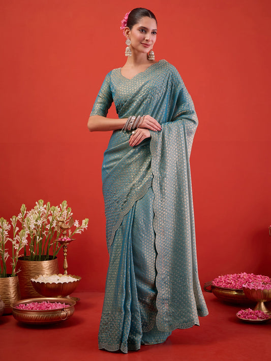 Woman wearing light blue satin saree with ornamented surface design and light blue blouse