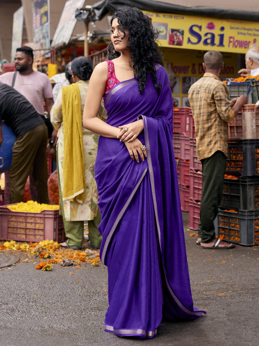 Woman wearing violet cotton blend saree with clean solid-tone finish and pink blouse