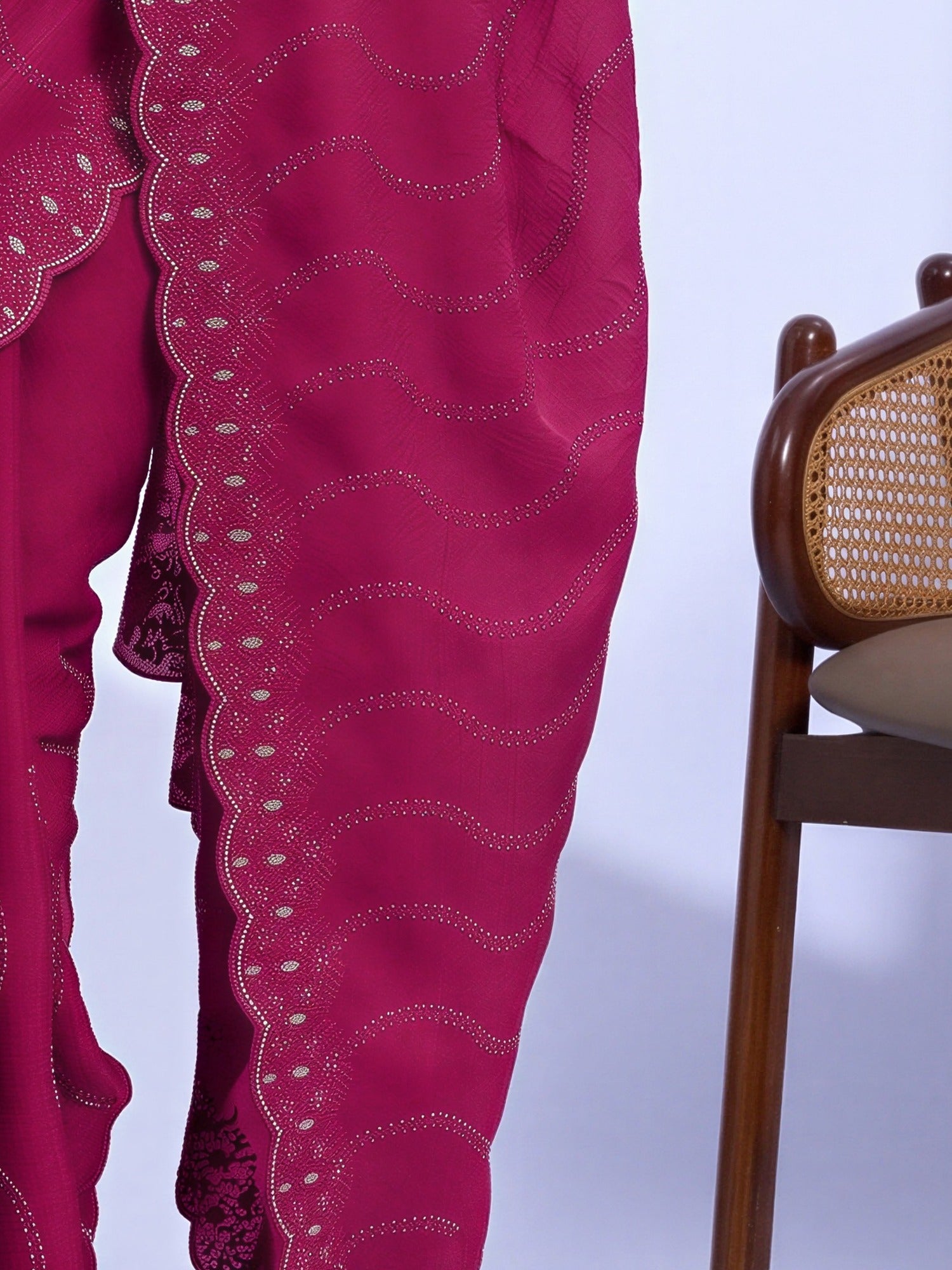 Pallu detail of pink tissue saree showing geometric pattern design and embellished border