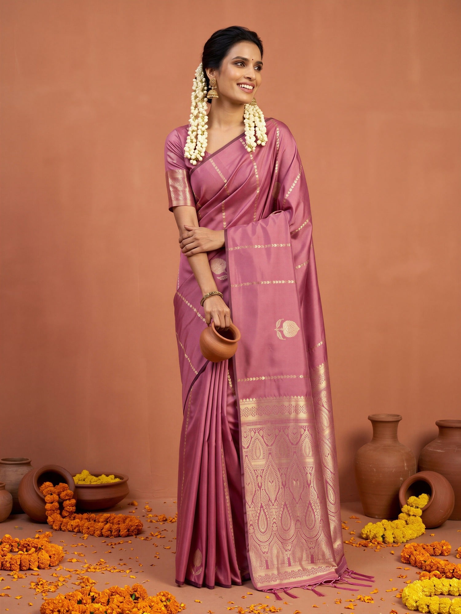 Woman wearing mauve satin silk saree with traditional indian motif work and mauve blouse