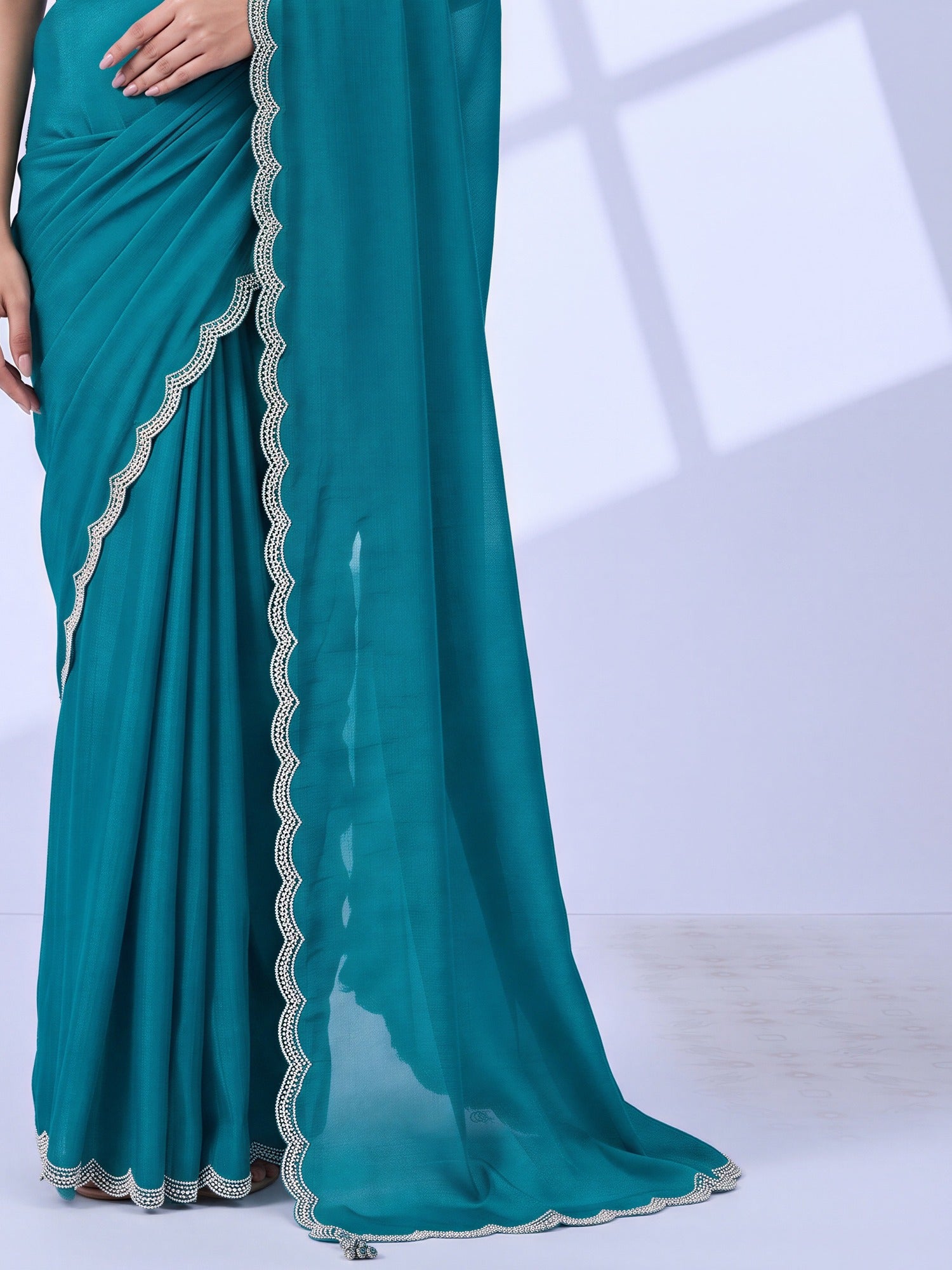 Pallu detail of light blue chiffon saree showing embroidered motif work and embellished border