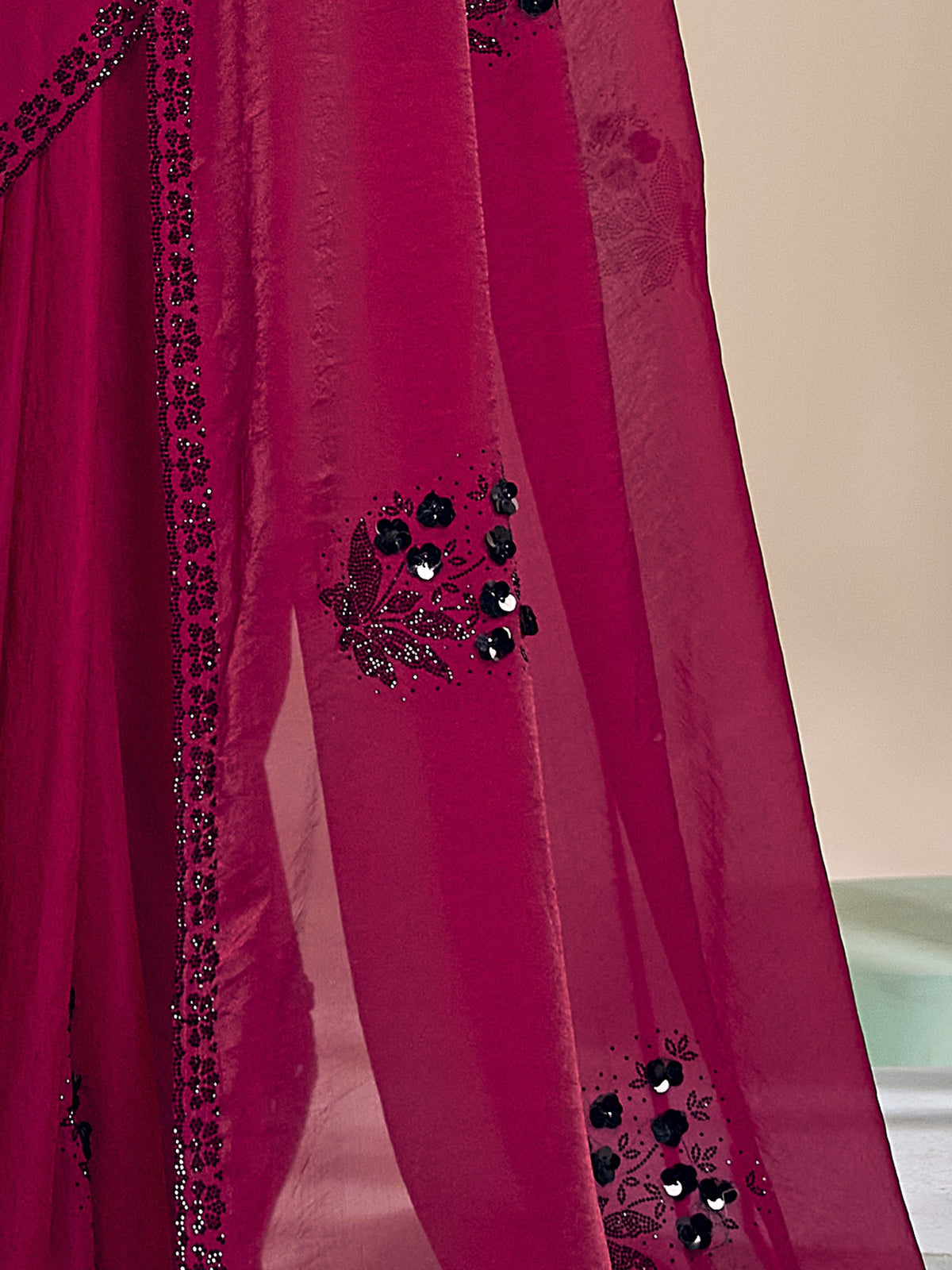 Pallu detail of magenta satin silk saree showing ornamented surface design and scallop border