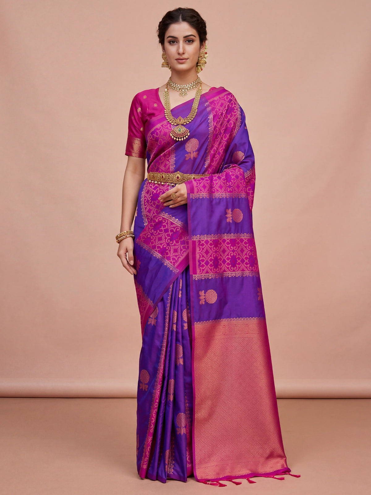 Woman wearing purple pure silk saree with ornamented surface design and magenta blouse
