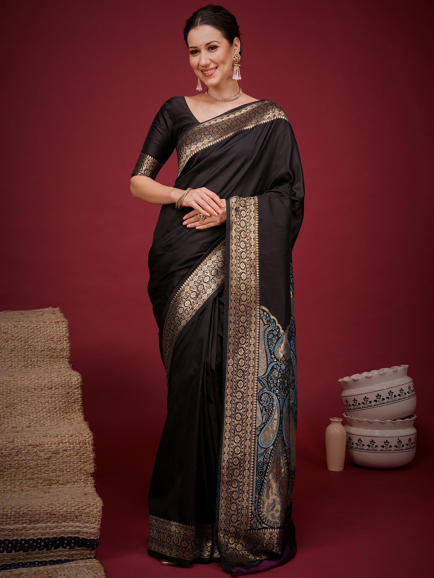 Woman wearing black soft silk saree with woven motif design and black blouse