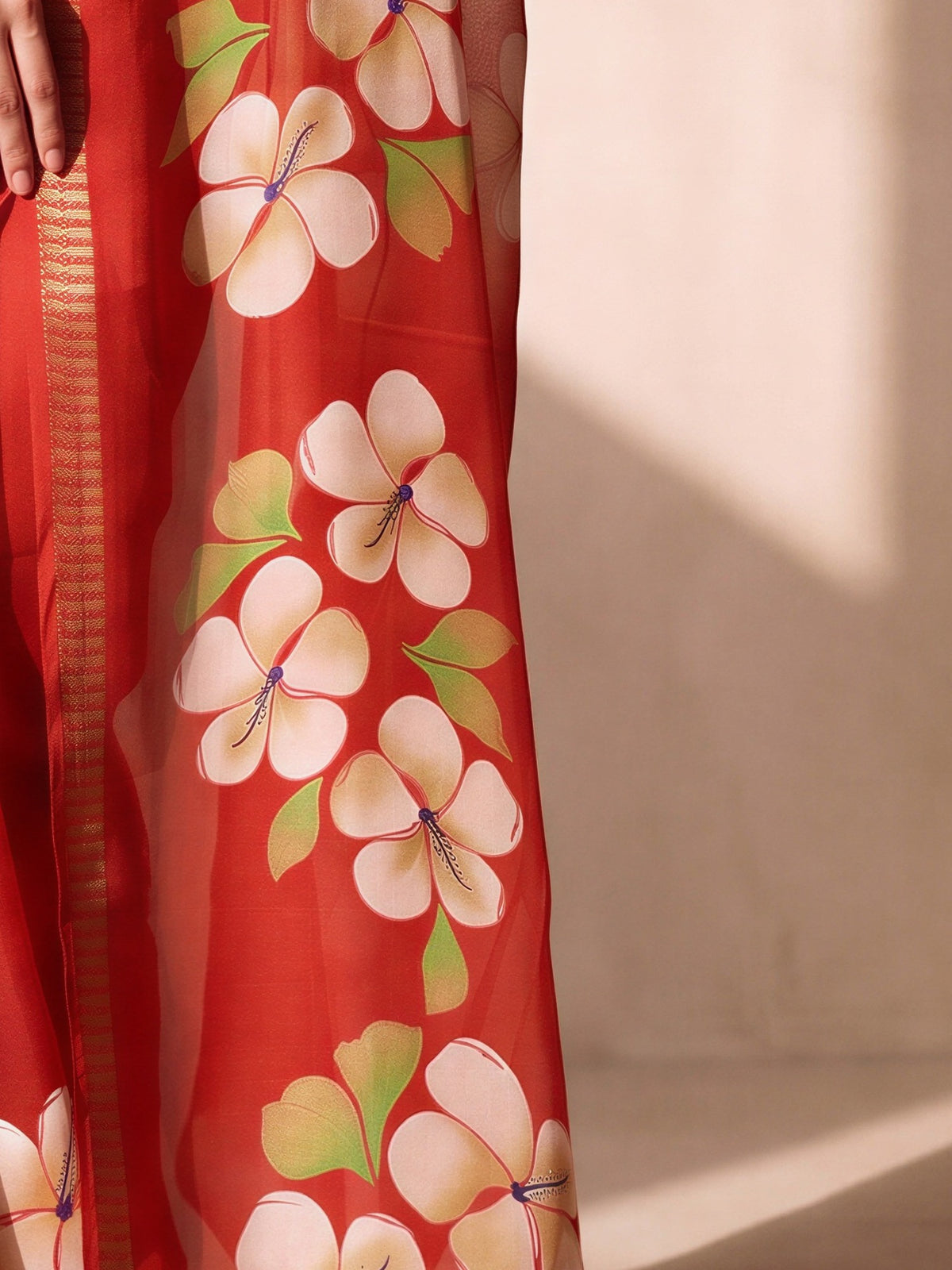 Pallu detail of red georgette saree showing all-over floral design and zari border