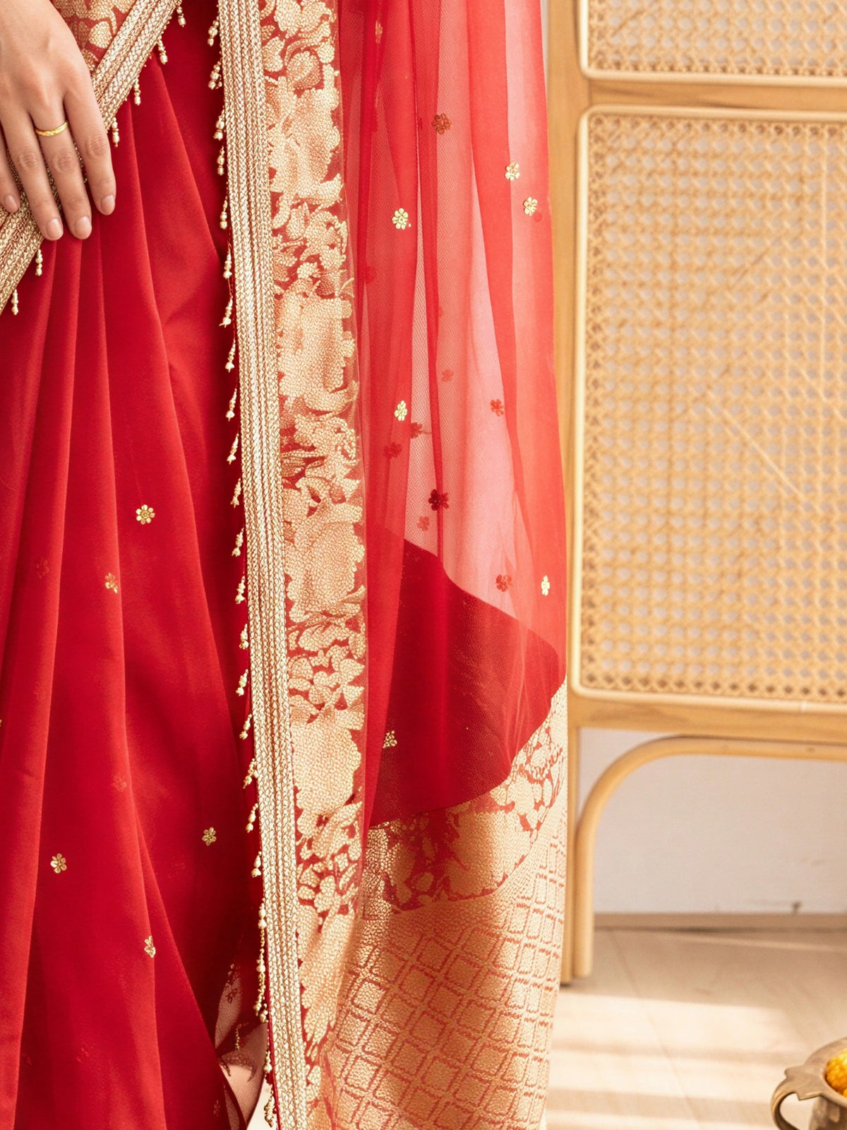 Pallu detail of red silk blend saree showing traditional indian motif work and zari border