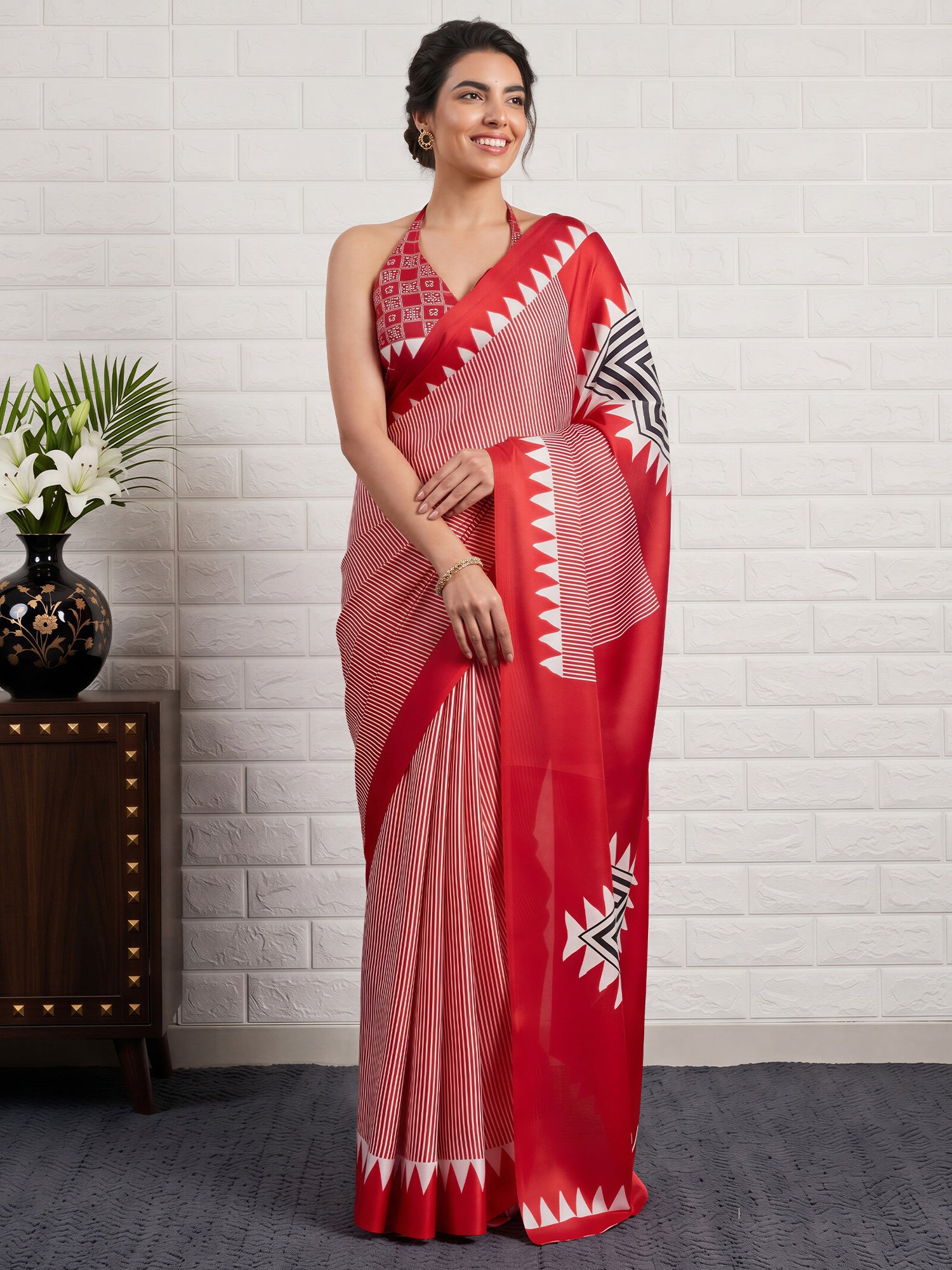 Woman wearing red satin silk saree with striped pattern design and red blouse